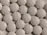 A close-up view of numerous white, round, tablet-like pills with markings '30' and 'M' embossed on them. The pills are arranged in a scattered pattern filling the entire frame.