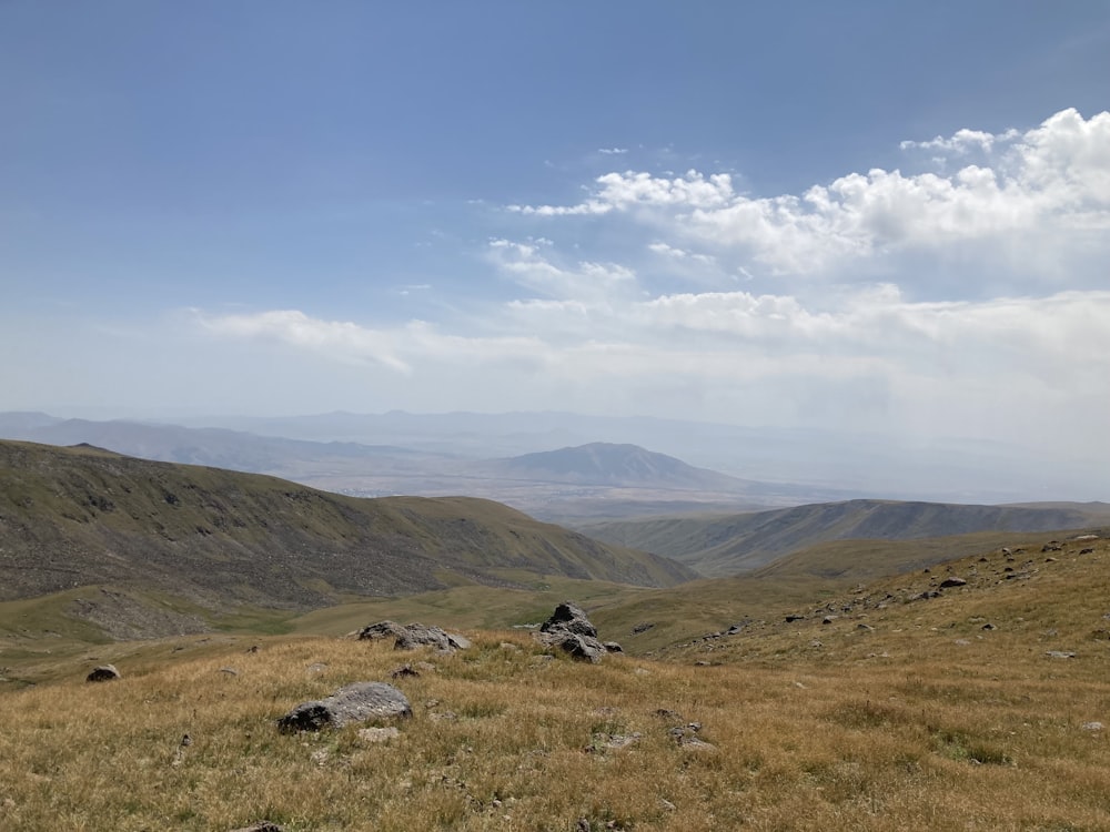 a grassy area with hills in the background