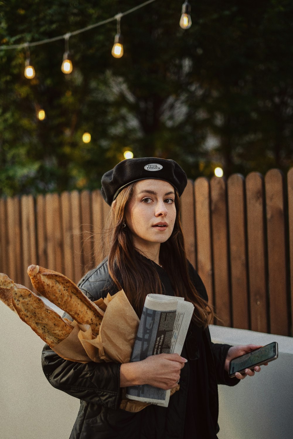 a person holding a book and a bag of bread