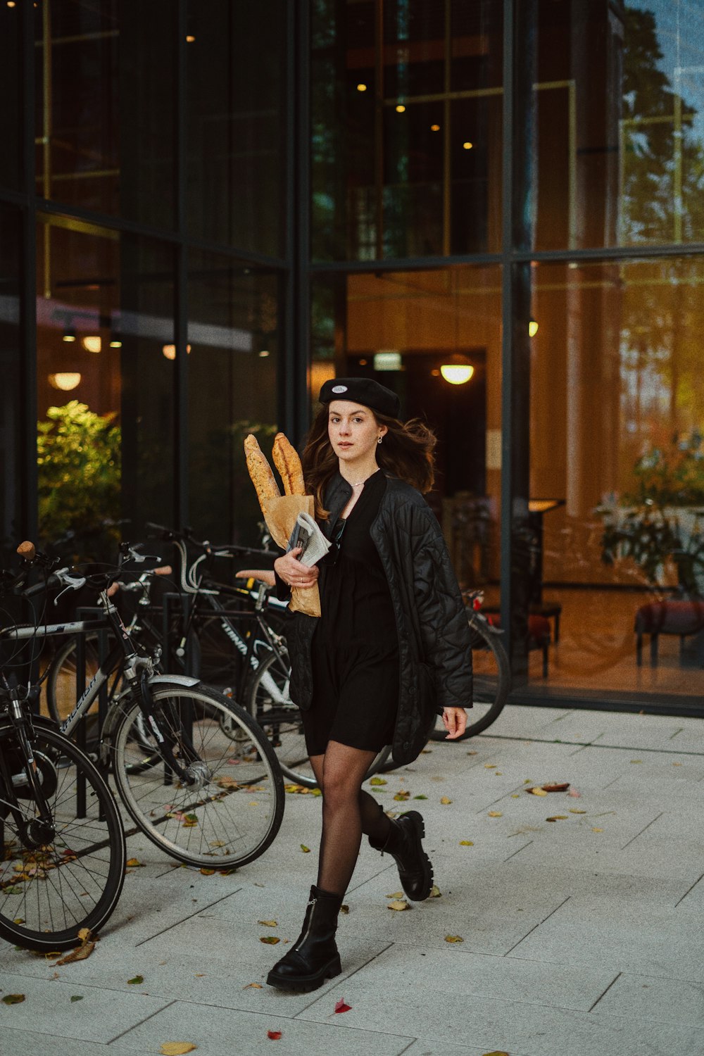 a person in a black hat and coat holding a book