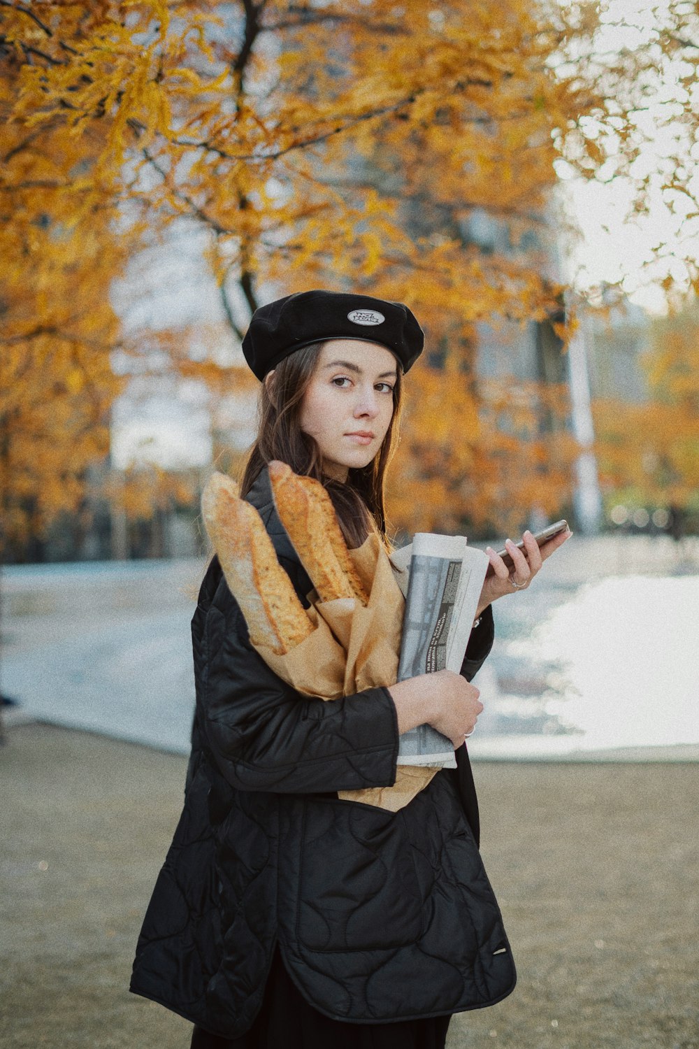una persona con un cappello nero e un cappotto che tiene un giornale