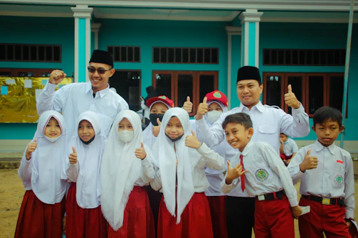Smiling teacher assisting students during a school event.
