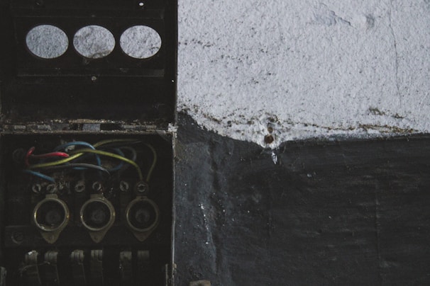 Close-up of hands connecting wires inside an electrical junction box.
