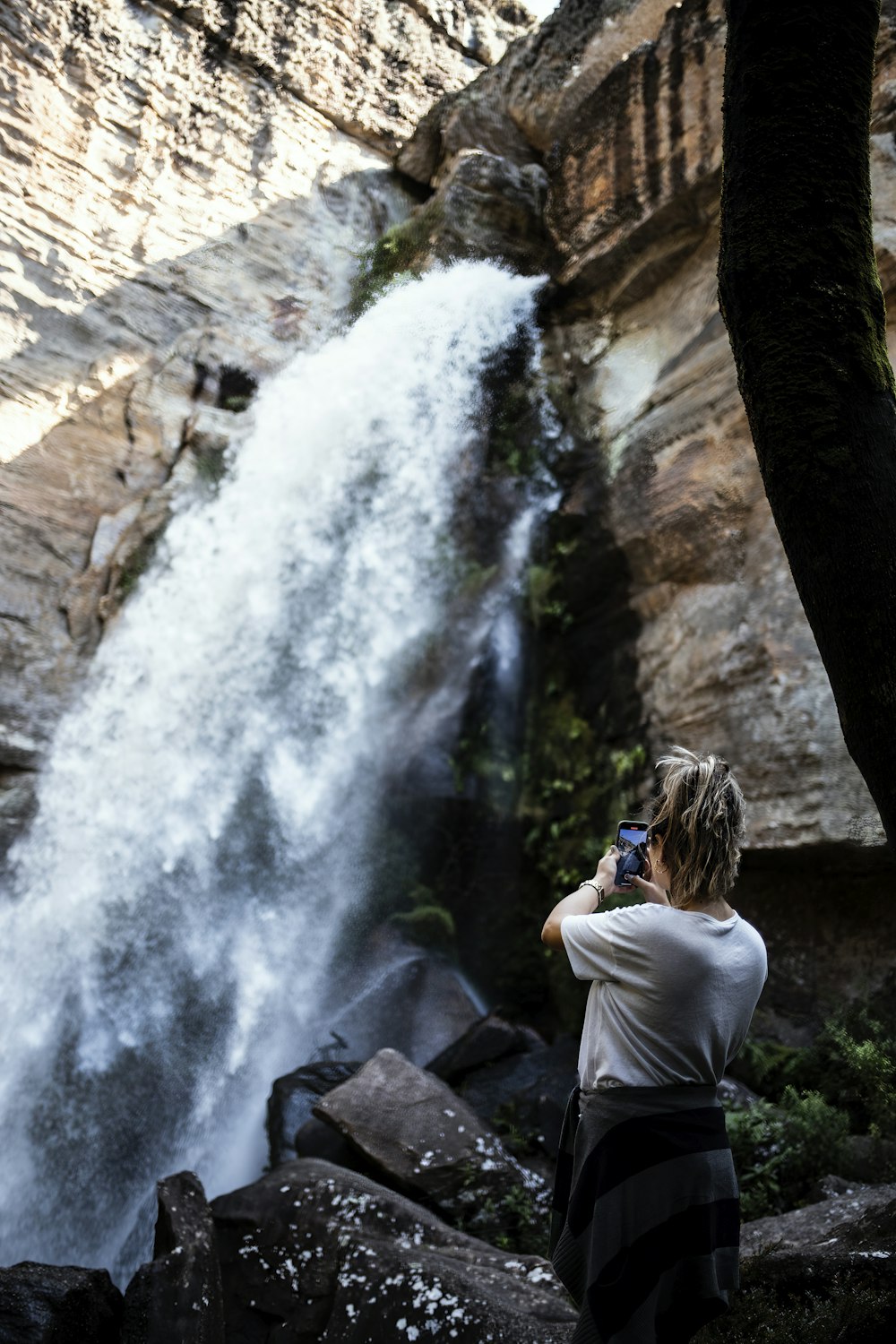 a man taking a picture of a waterfall