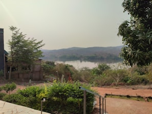 A serene landscape with a river and pumping station in the background.