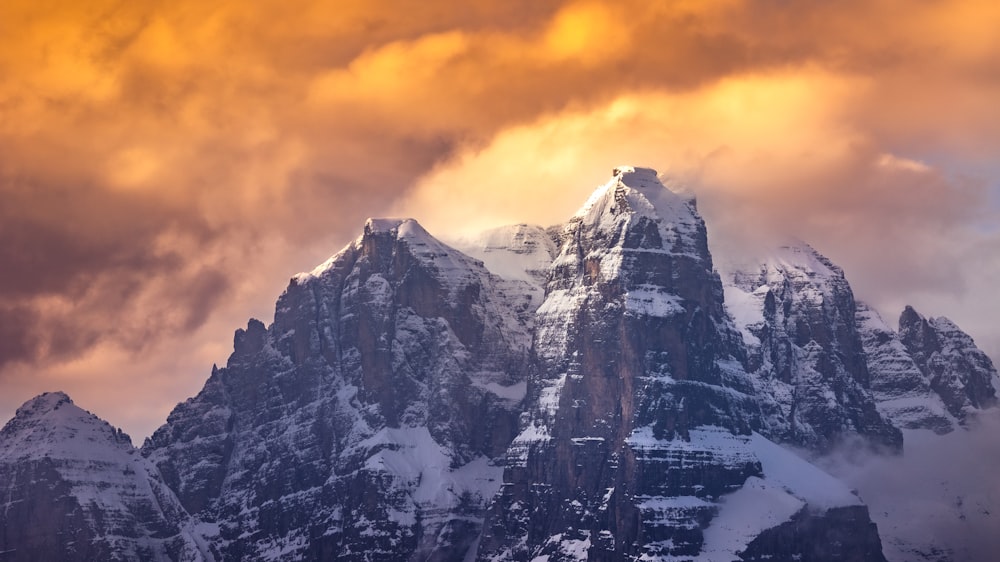 a snowy mountain with a cloudy sky