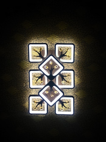 Close-up of a decorative light fixture featuring intricate geometric patterns in matte black finish.