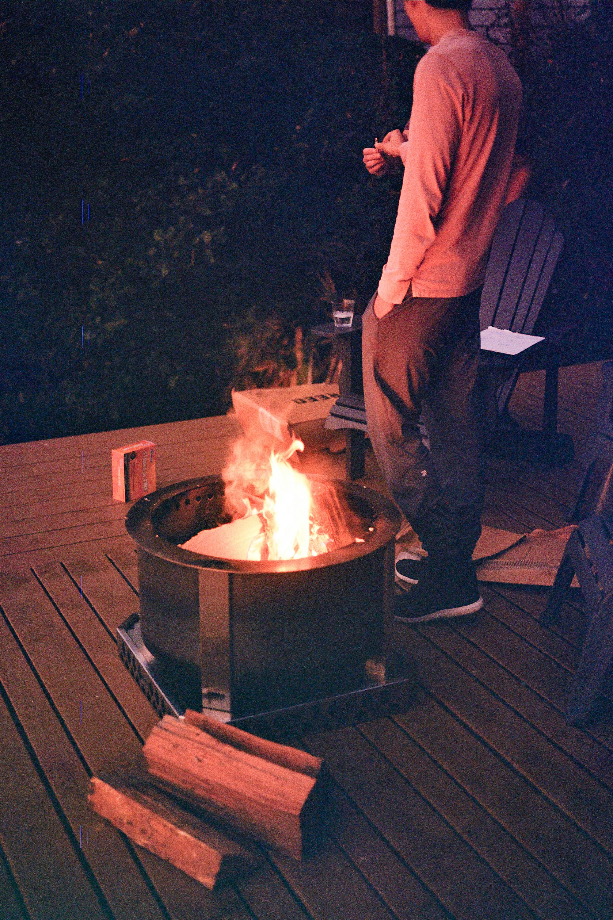a man standing next to a fire