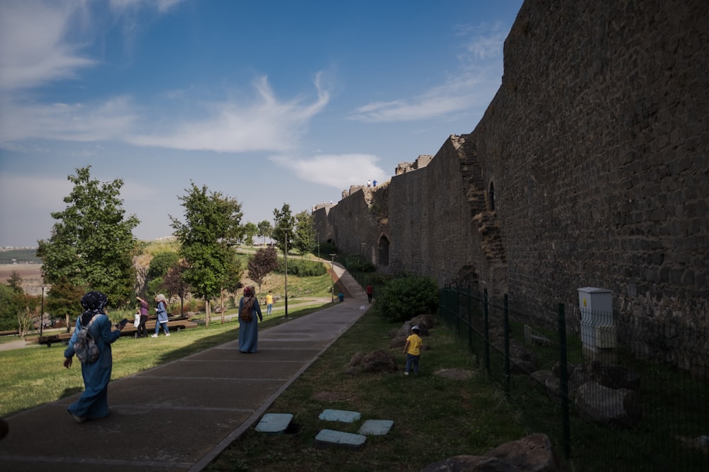 personnes marchant sur un chemin entre des murs de pierre
