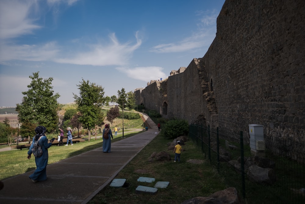 people walking on a path between stone walls