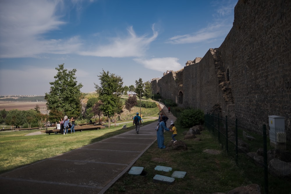 Gente caminando por un sendero entre edificios de piedra