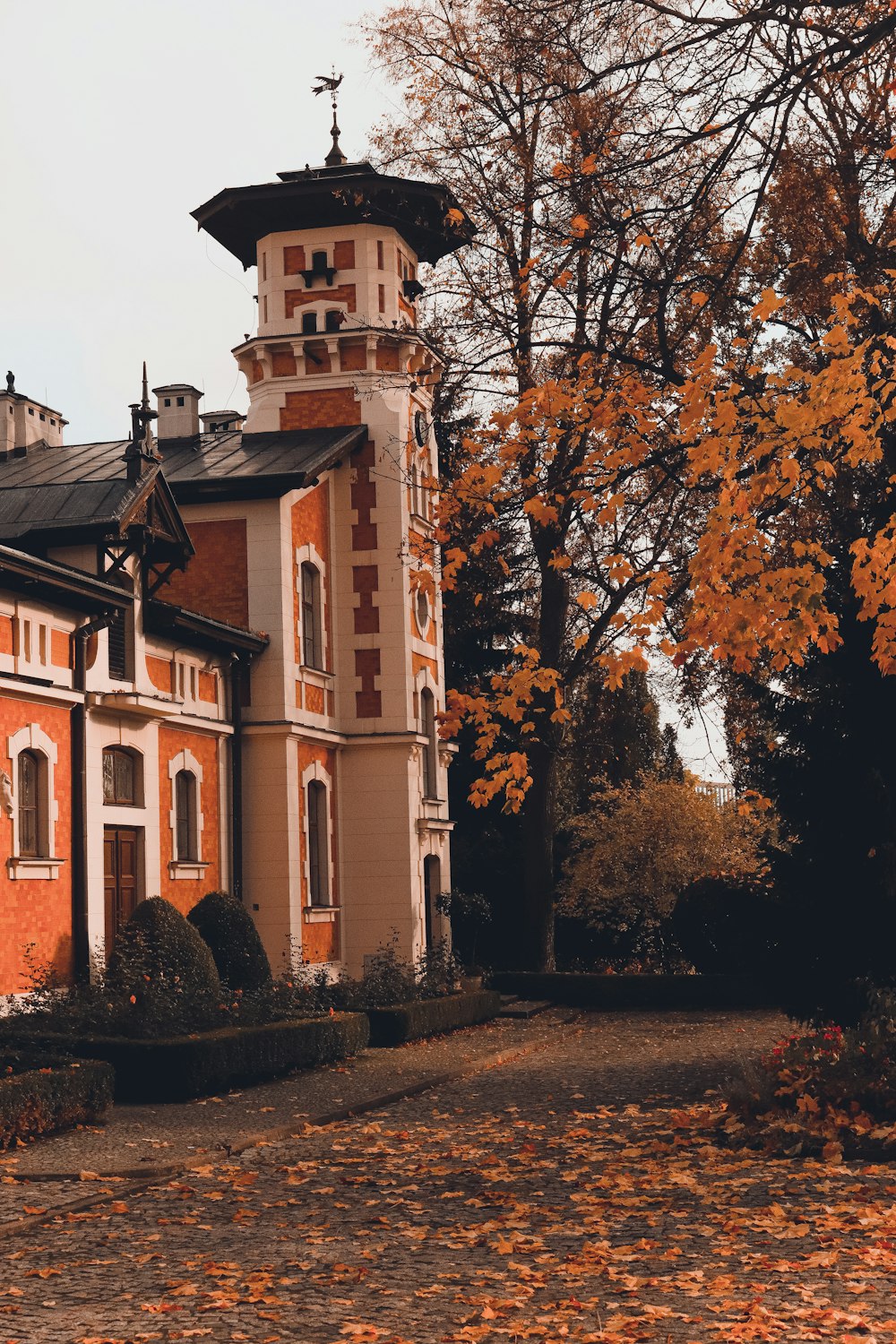 a building with a tower and trees around it