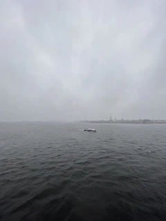 Daniel steering his boat along the misty Hudson River at dawn, with Sleepy Hollow's shoreline in the background.