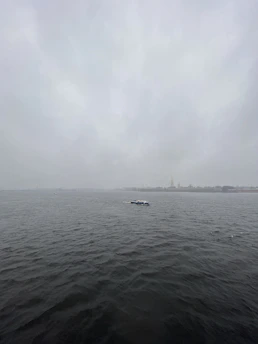 Daniel steering his boat along the misty Hudson River at dawn, with Sleepy Hollow's shoreline in the background.