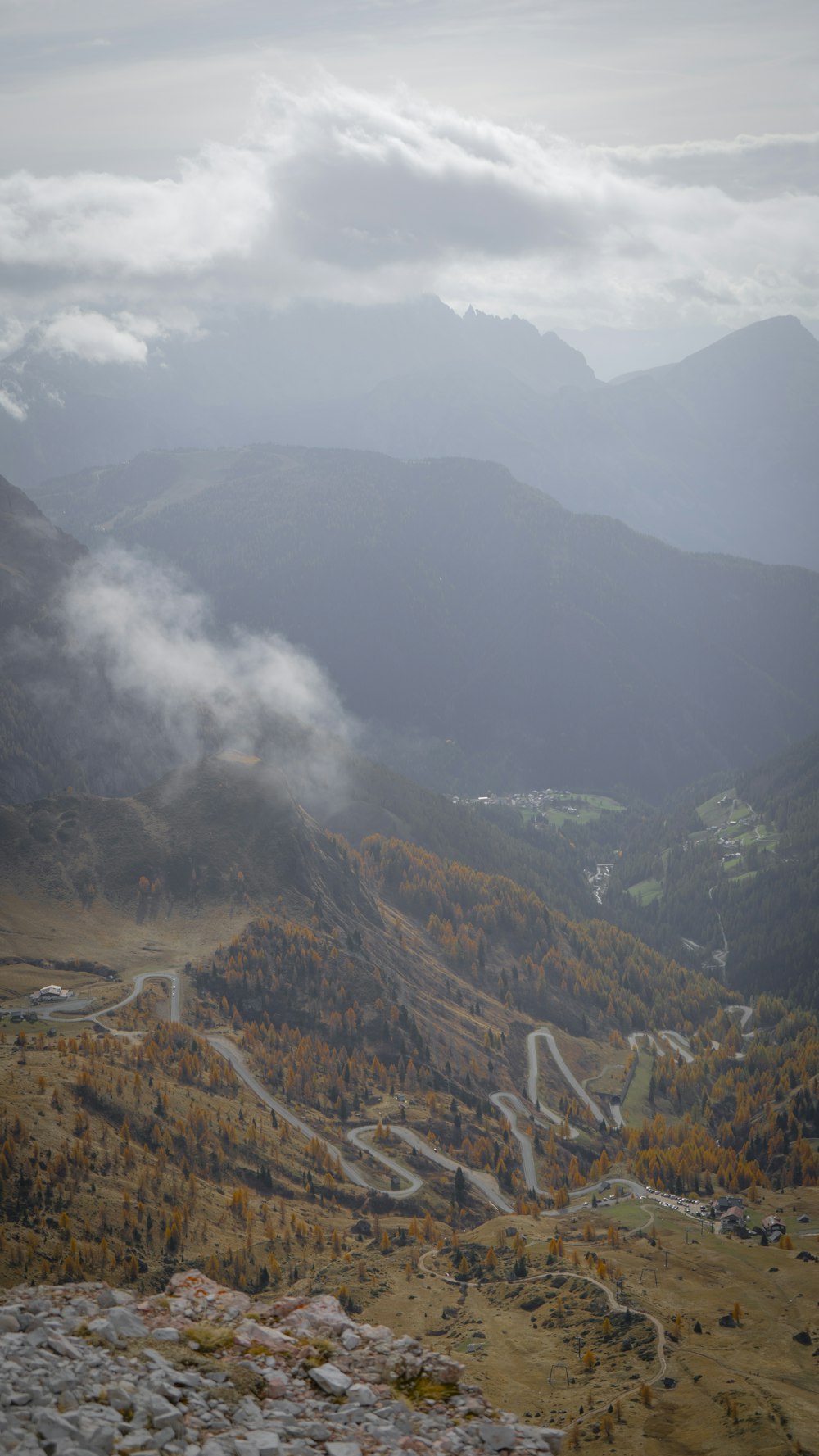 a valley with a road and mountains in the background