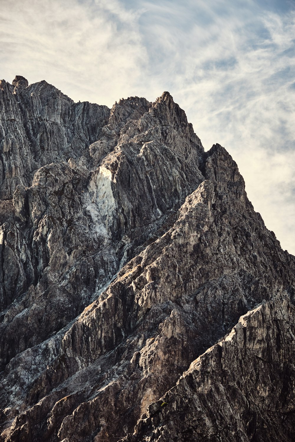 a rocky mountain with a cloudy sky