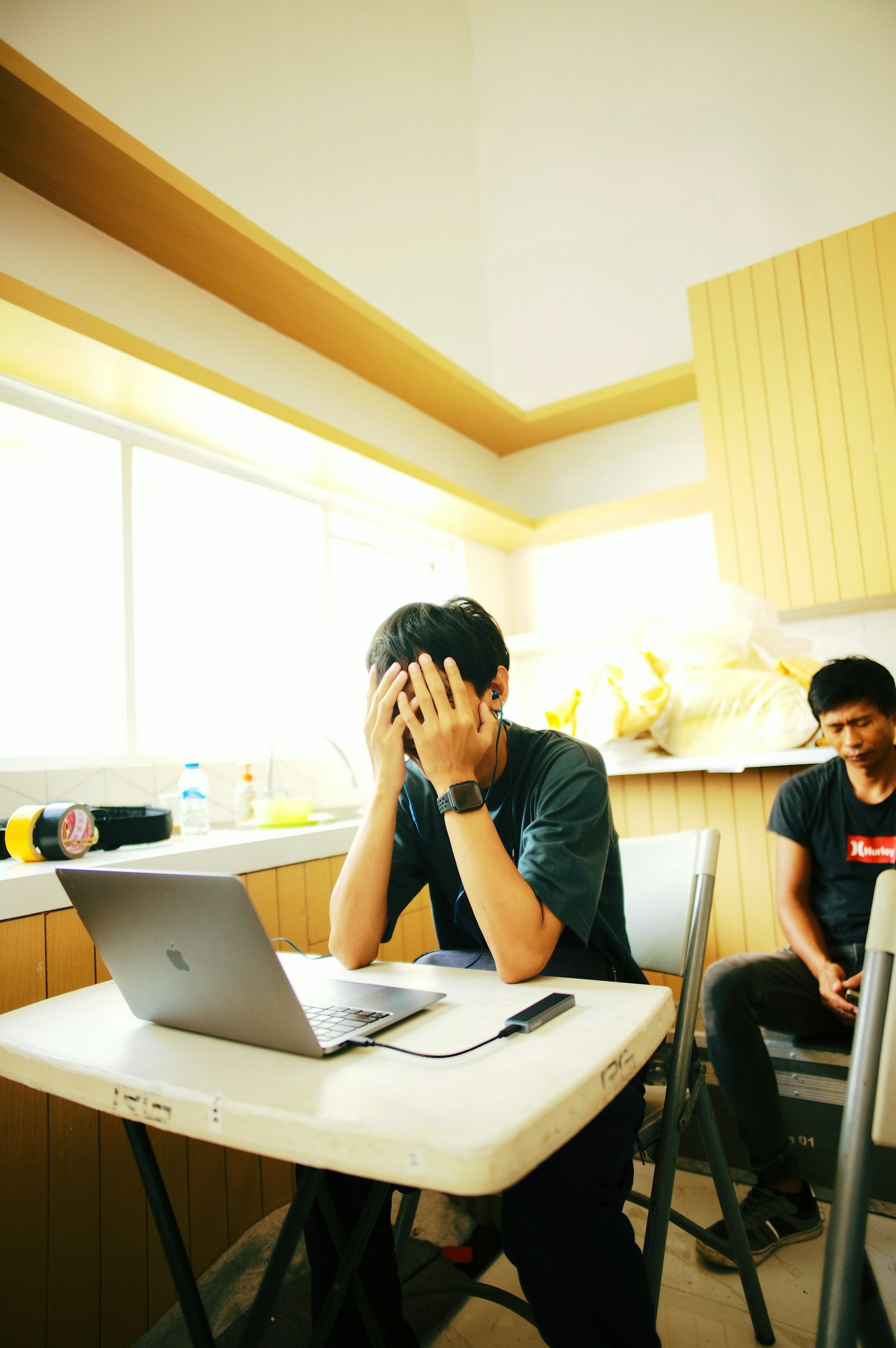 A person at a desk working across a laptop and phone