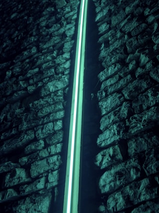 a light shining through a stone wall