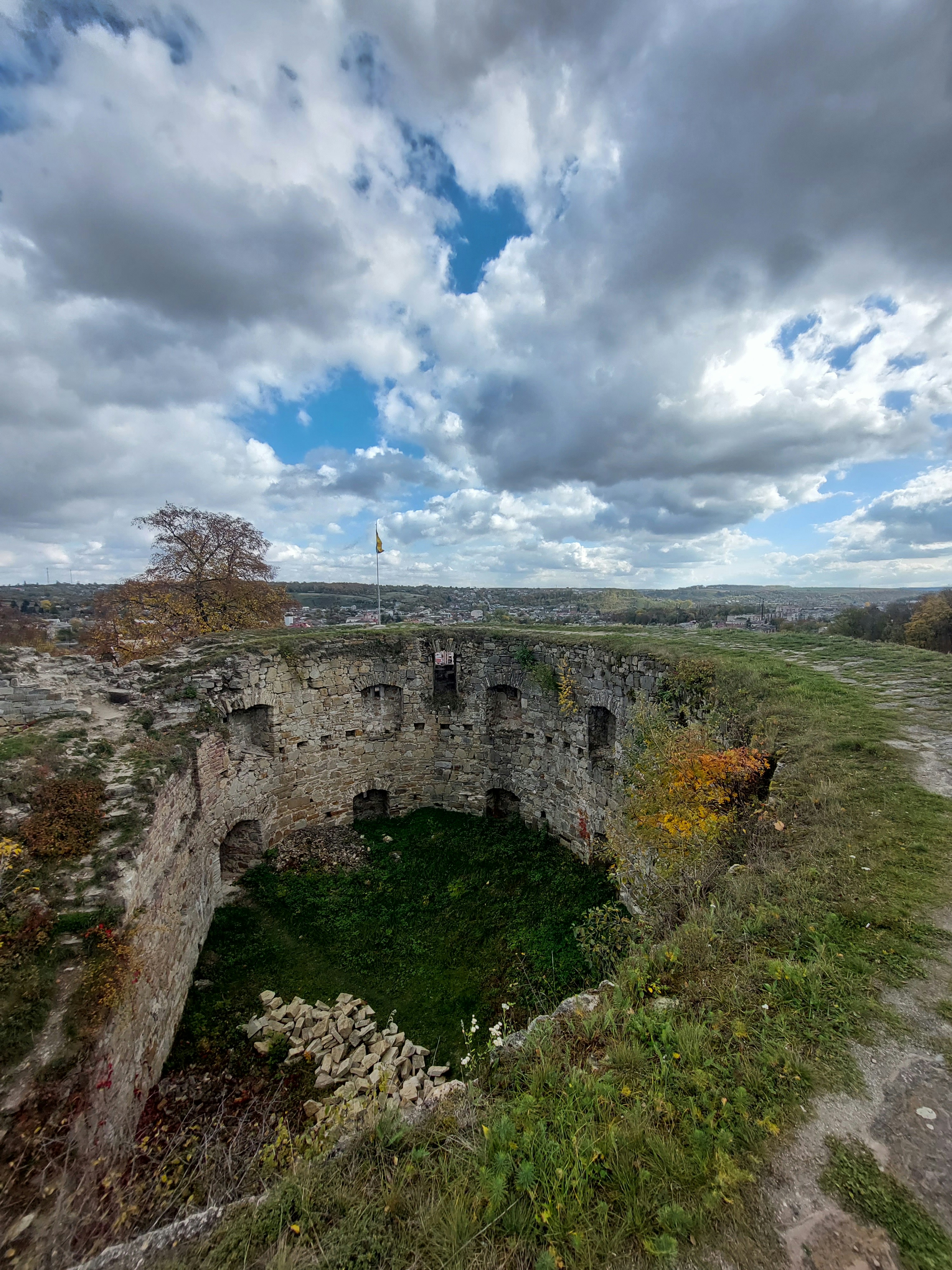 un muro de piedra con un muro de piedra y hierba y árboles
