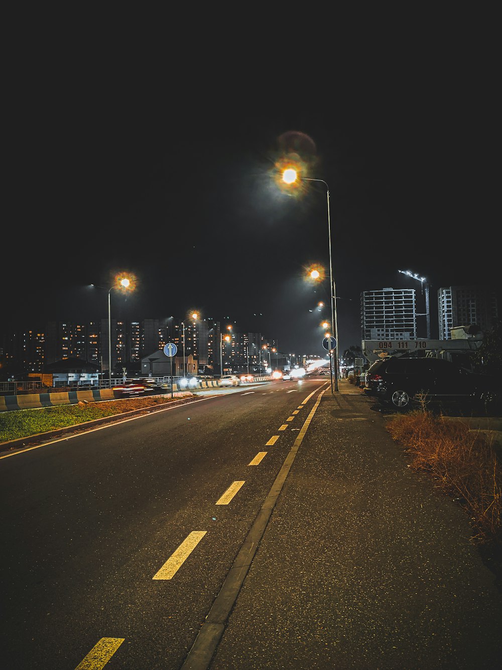 a road with cars on it and buildings in the background