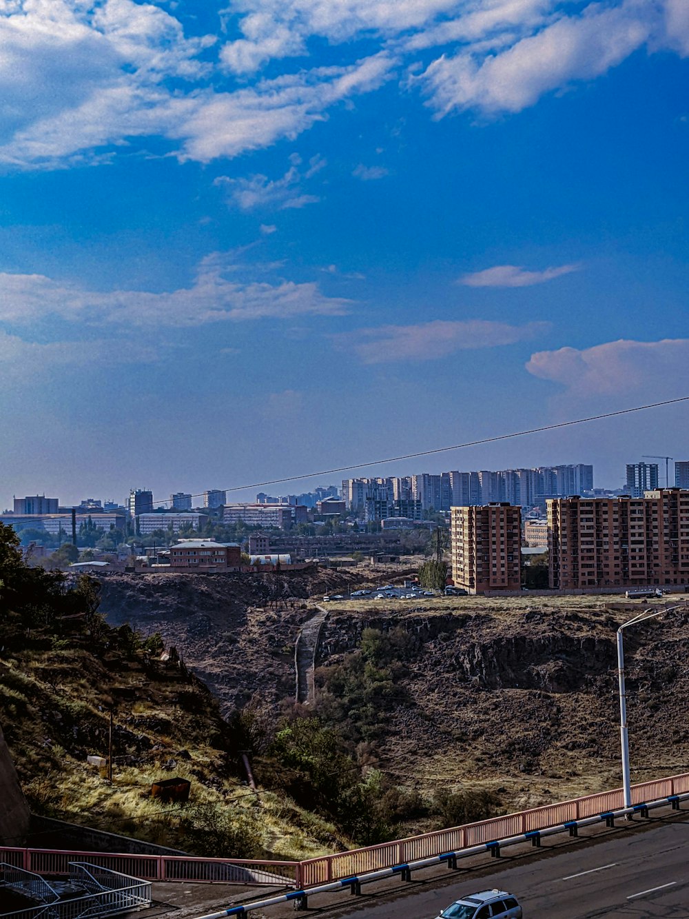 a city with a hill and a road with a car on it