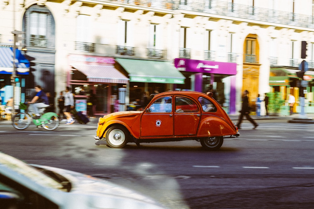 a small orange car on a street