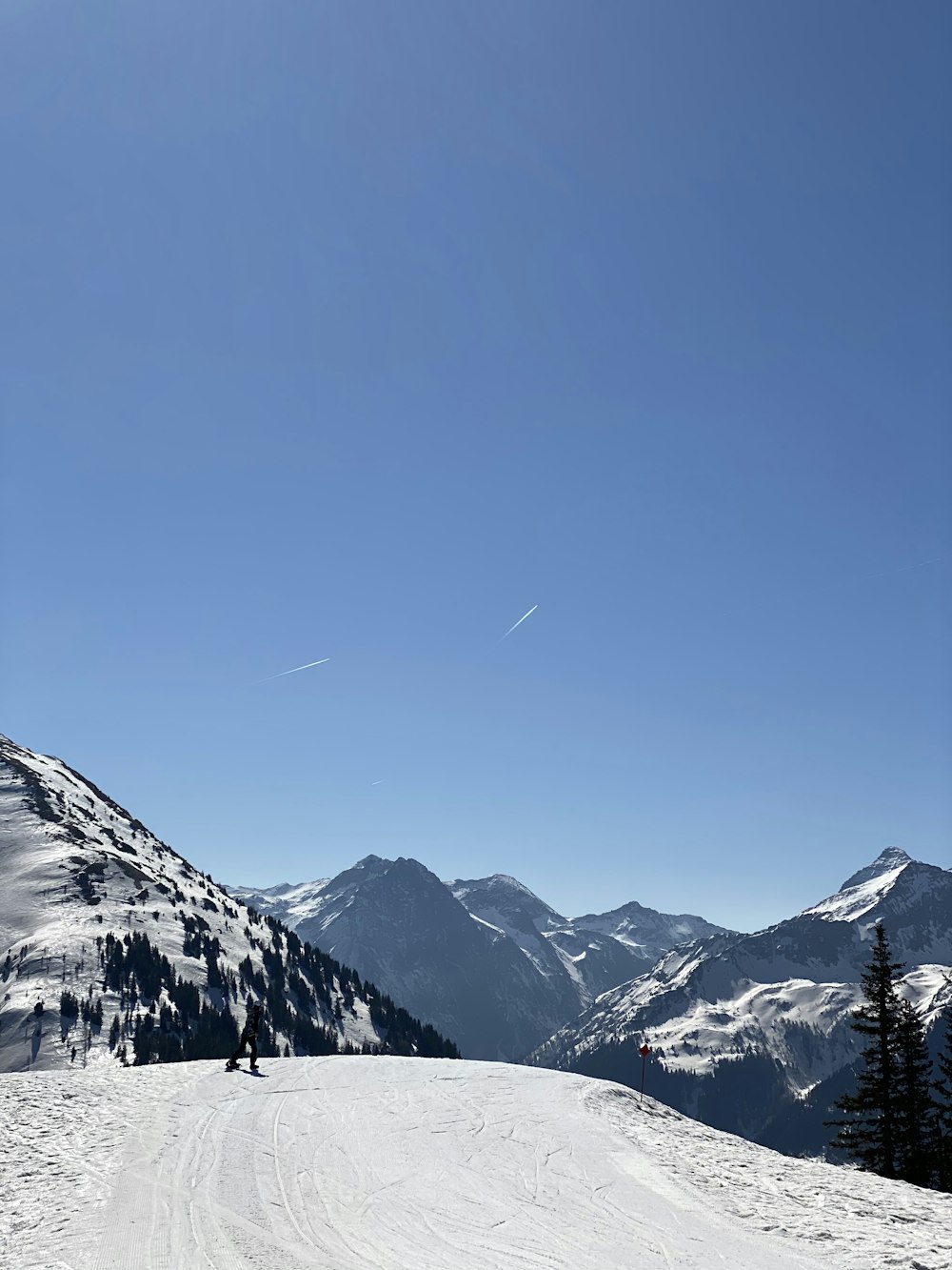 a snowy mountain with a trail of people on it