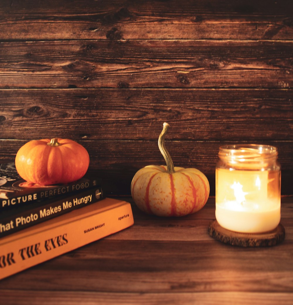 a group of pumpkins and a candle on a table