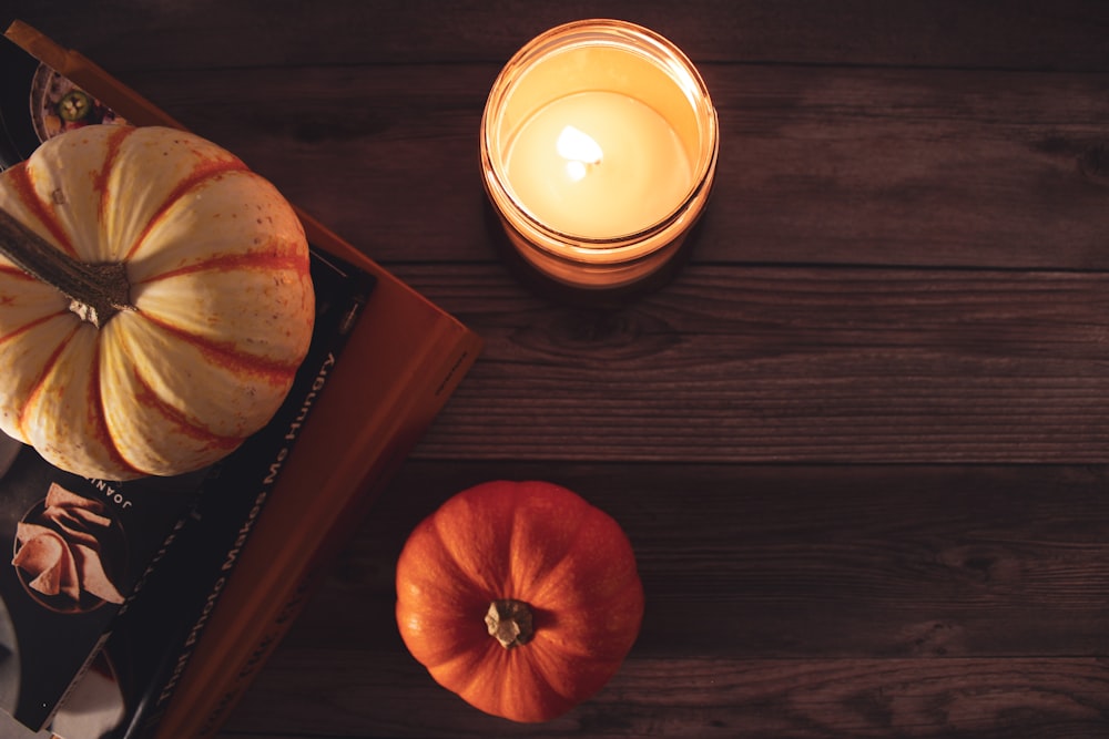 a candle next to a carved pumpkin