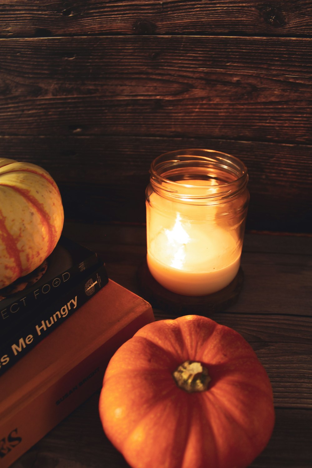 a candle next to a pumpkin