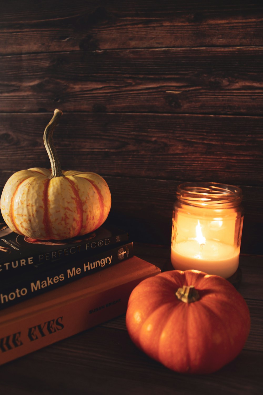 a group of pumpkins and a candle on a table