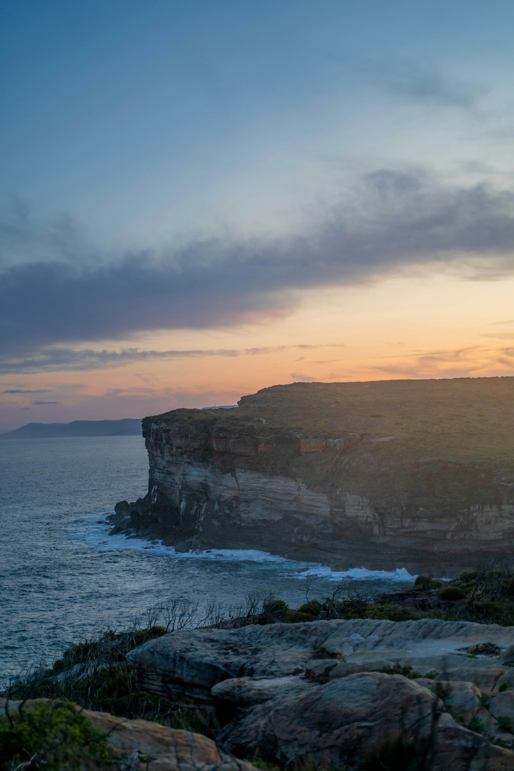 a rocky cliff next to a body of water