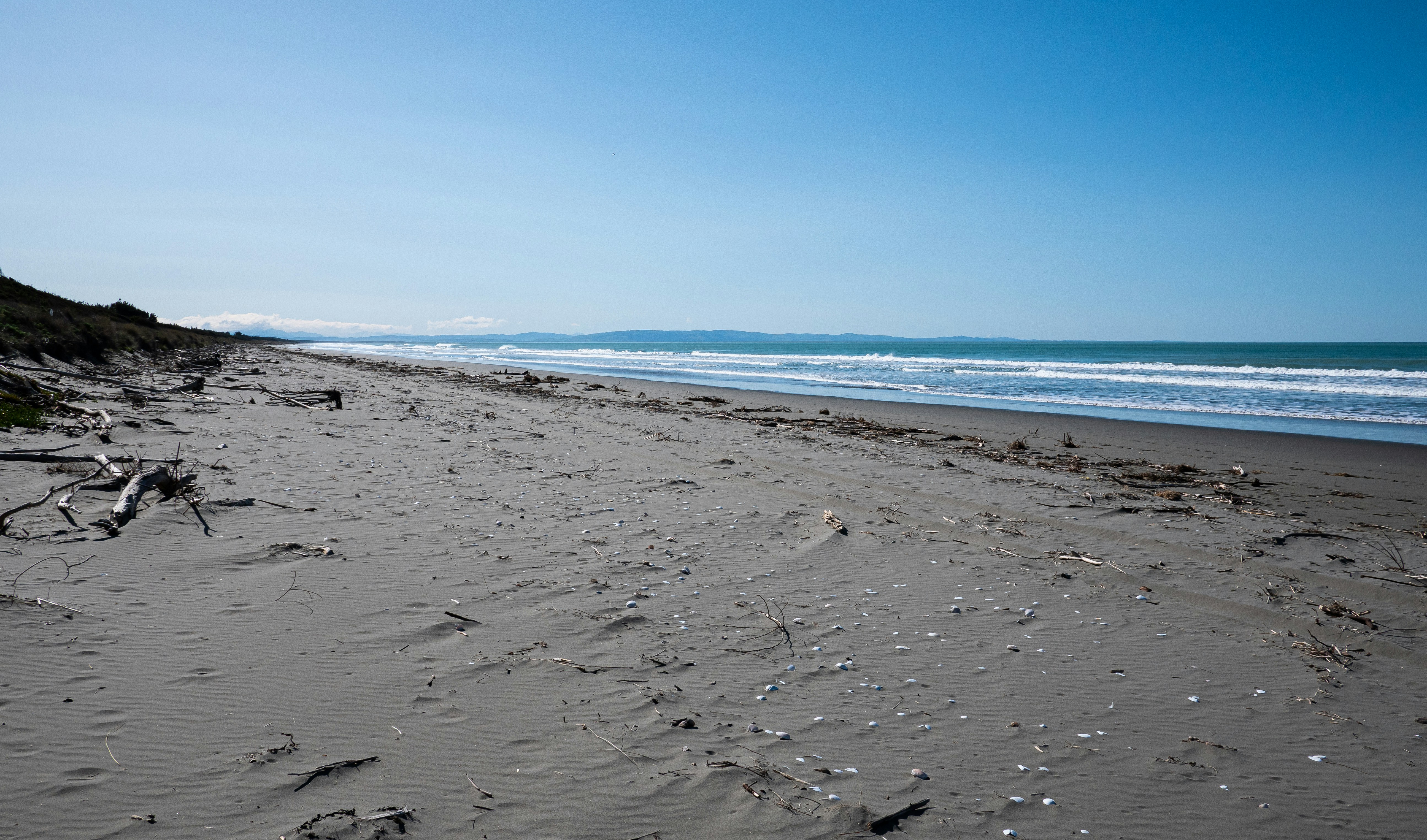 a sandy beach with waves crashing on it