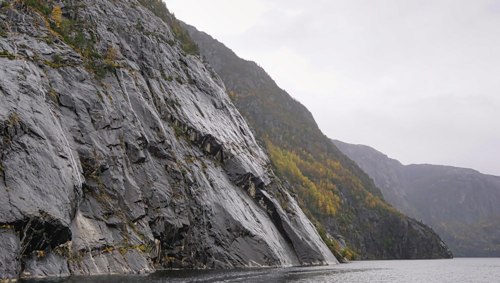 a rocky cliff next to a body of water