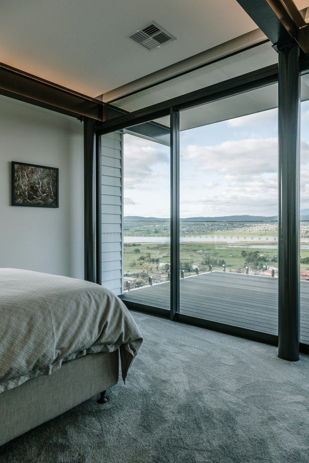 a room with a bed and a window with a view of a city