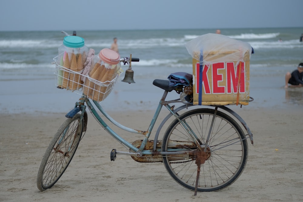 una bicicleta con una cesta de helado en una playa