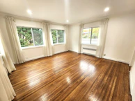 Bright bedroom with large windows and comfortable furnishings ready for new tenants.