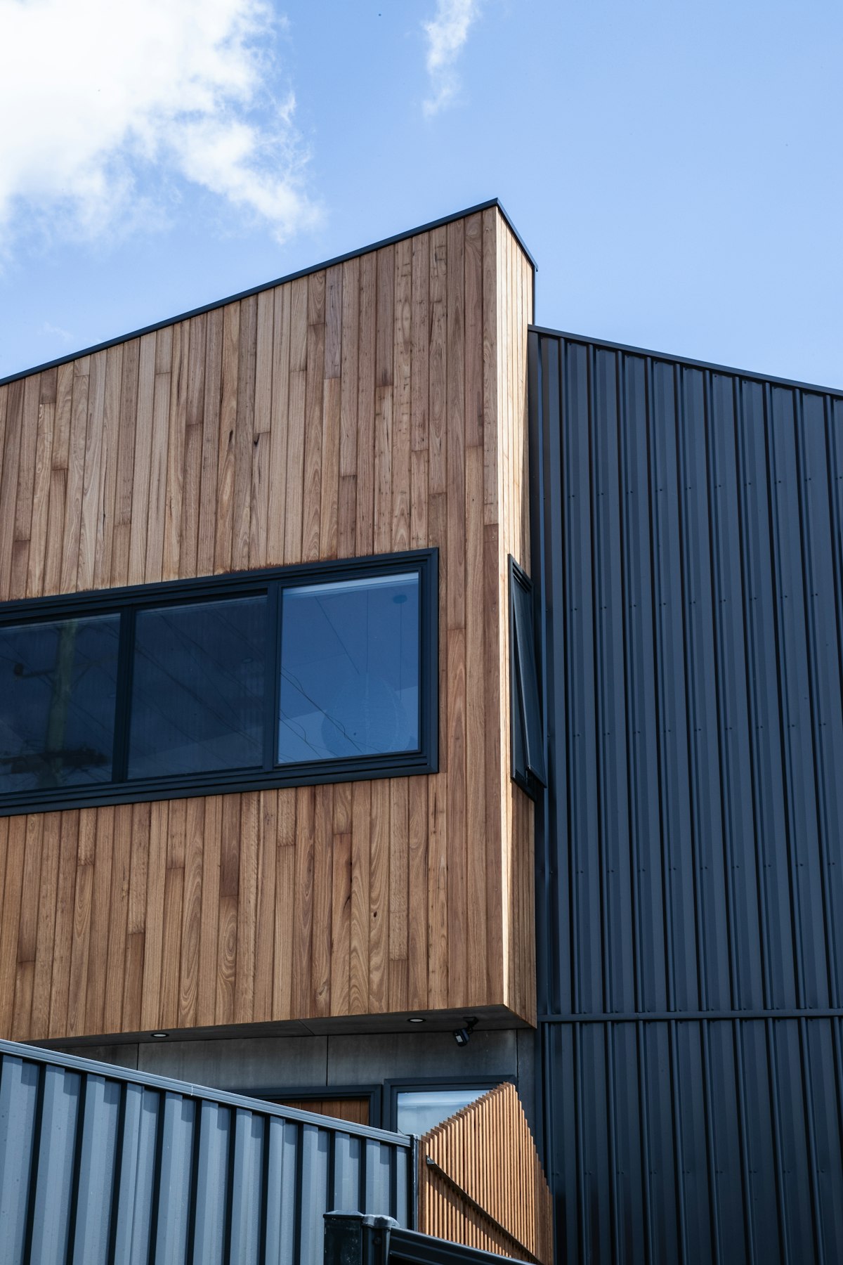 Modern building with timber and metal cladding, showing the combination of natural and recycled materials in contemporary sustainable construction