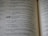 A close-up view of an open book displaying text in two columns. The text appears to be religious or philosophical in nature, with verses numbered and formatted in a poetic structure.