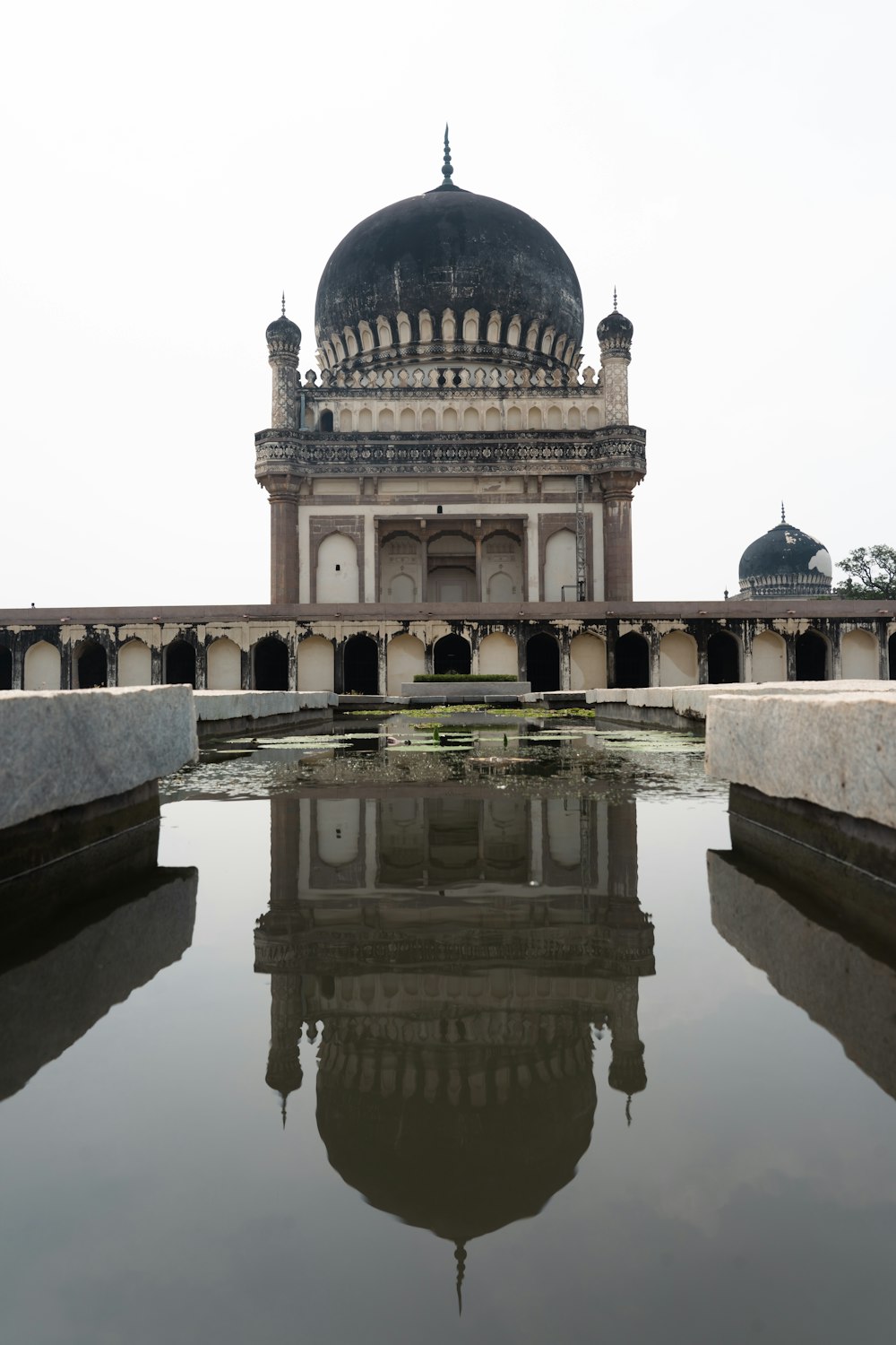 a large building with a dome and a reflection of the water