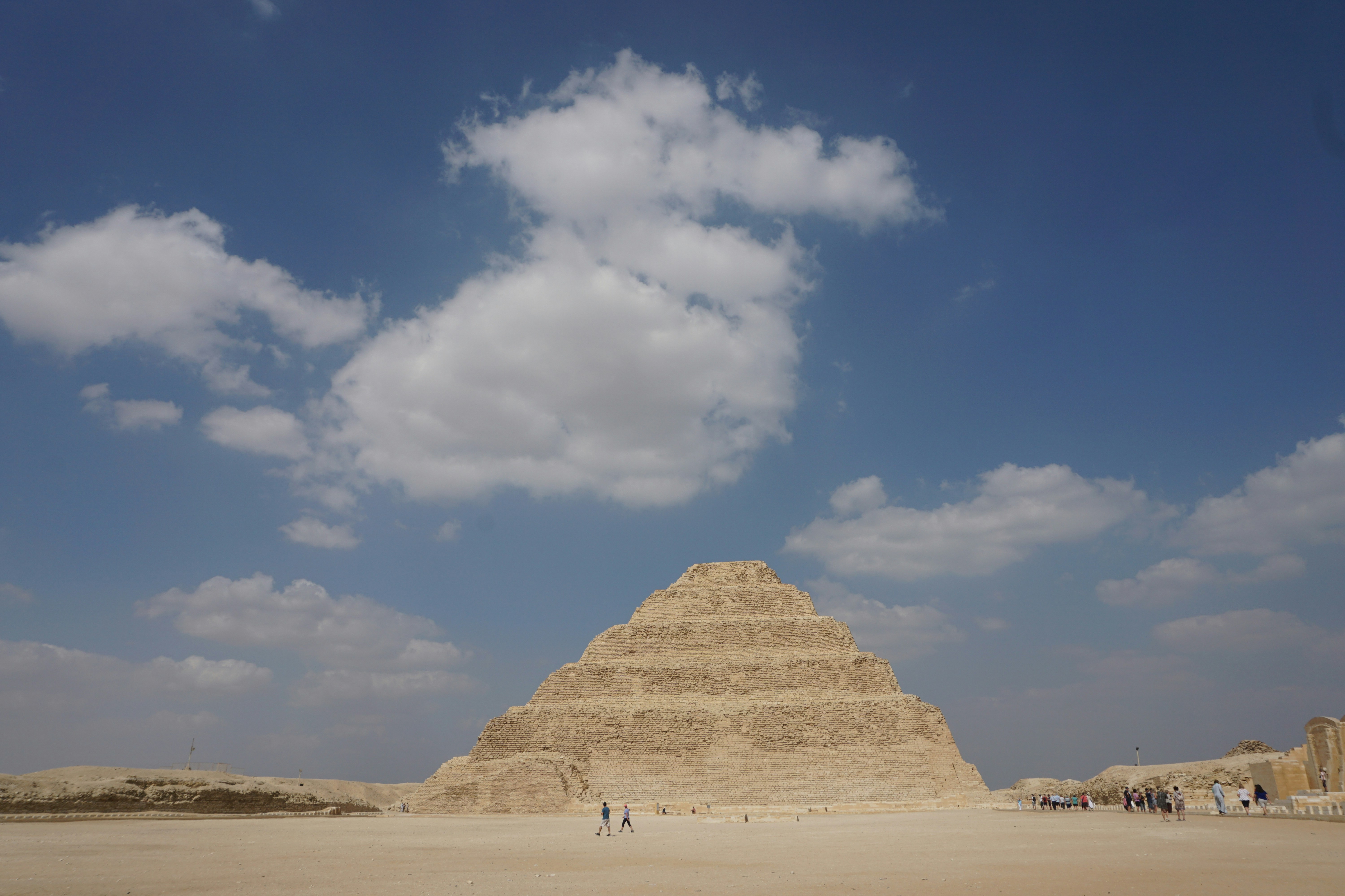 A group of people standing in front of a pyramid