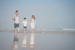 a group of people walking on a beach