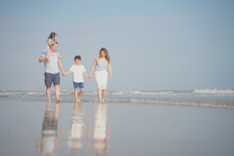 a group of people walking on a beach