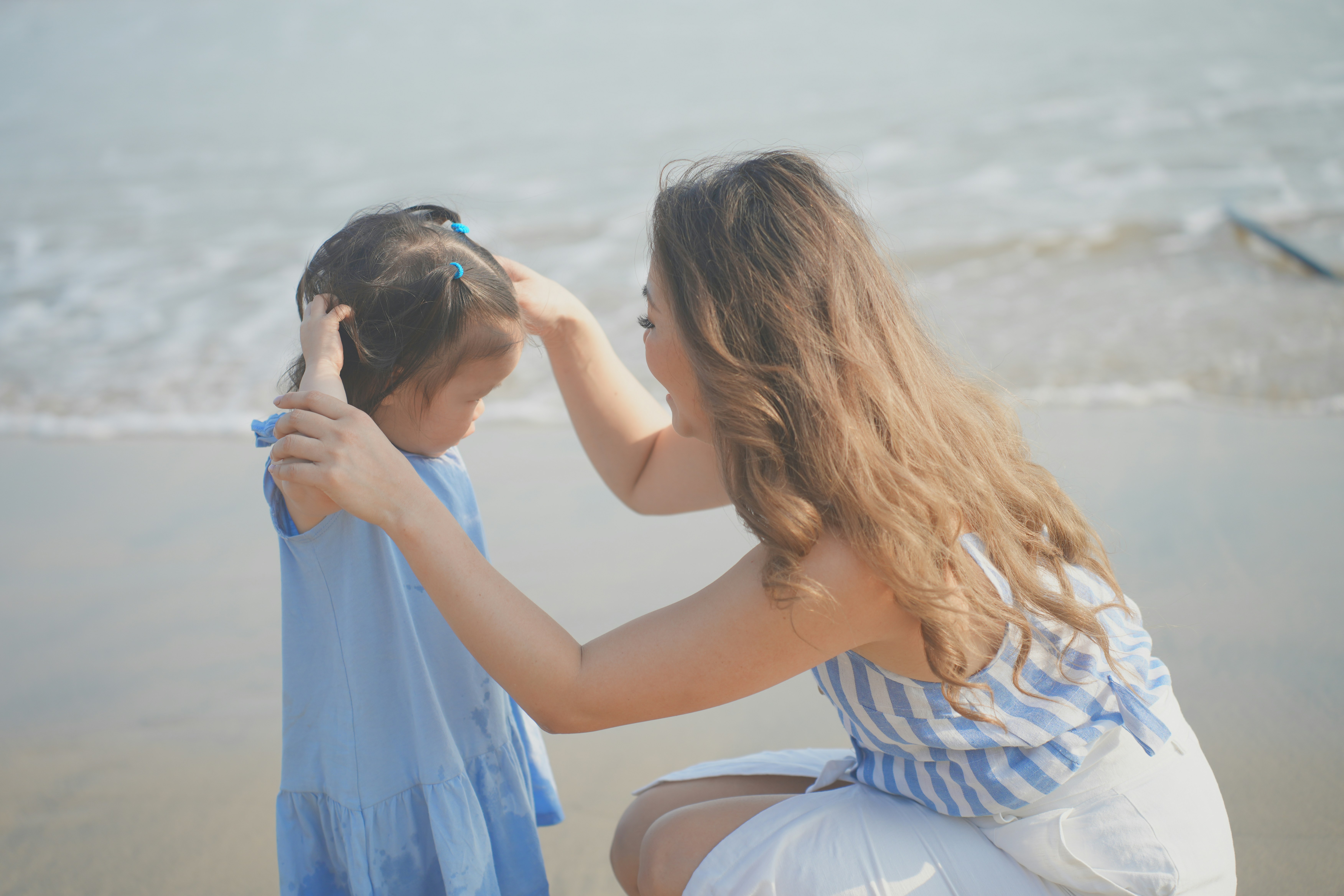 a woman kissing a man on the cheek on a beach