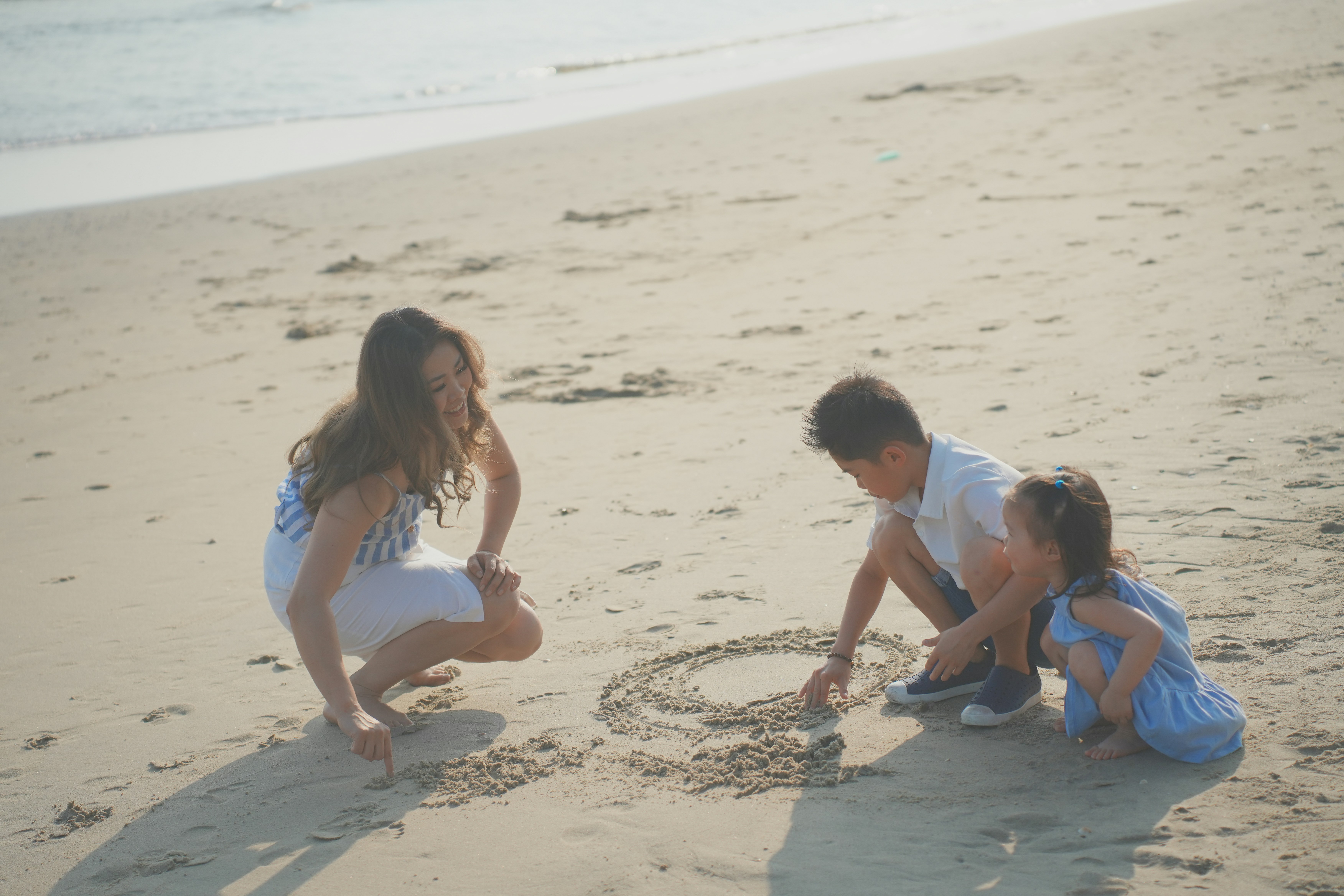 a group of people playing in the sand at the beach
