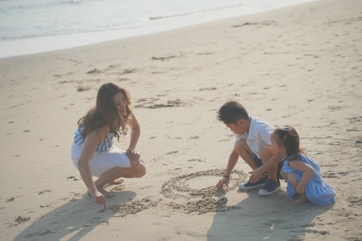a group of people playing in the sand at the beach