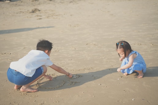 a boy and girl playing in the sand