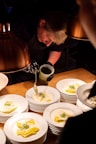 Close-up of a chef plating a gourmet pasta dish in an upscale kitchen.