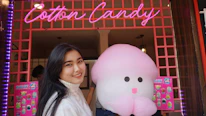 Group photo of our friendly collaborators smiling beside a cotton candy machine.