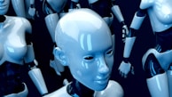 A grouping of sleek, humanoid robots made of shiny, reflective surfaces. Their designs feature smooth, polished exteriors with articulated joints and limbs. The central focus is on a robot's expressionless face, surrounded by others seen in various positions.